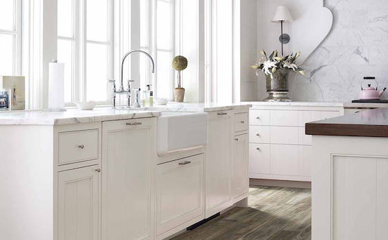 stunning white countertops in a bright kitchen with white cabinets and wood-look flooring